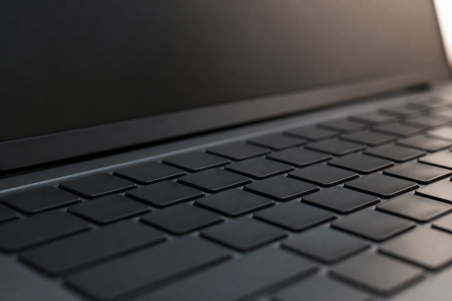 Close-up of a budget laptop keyboard and screen edge