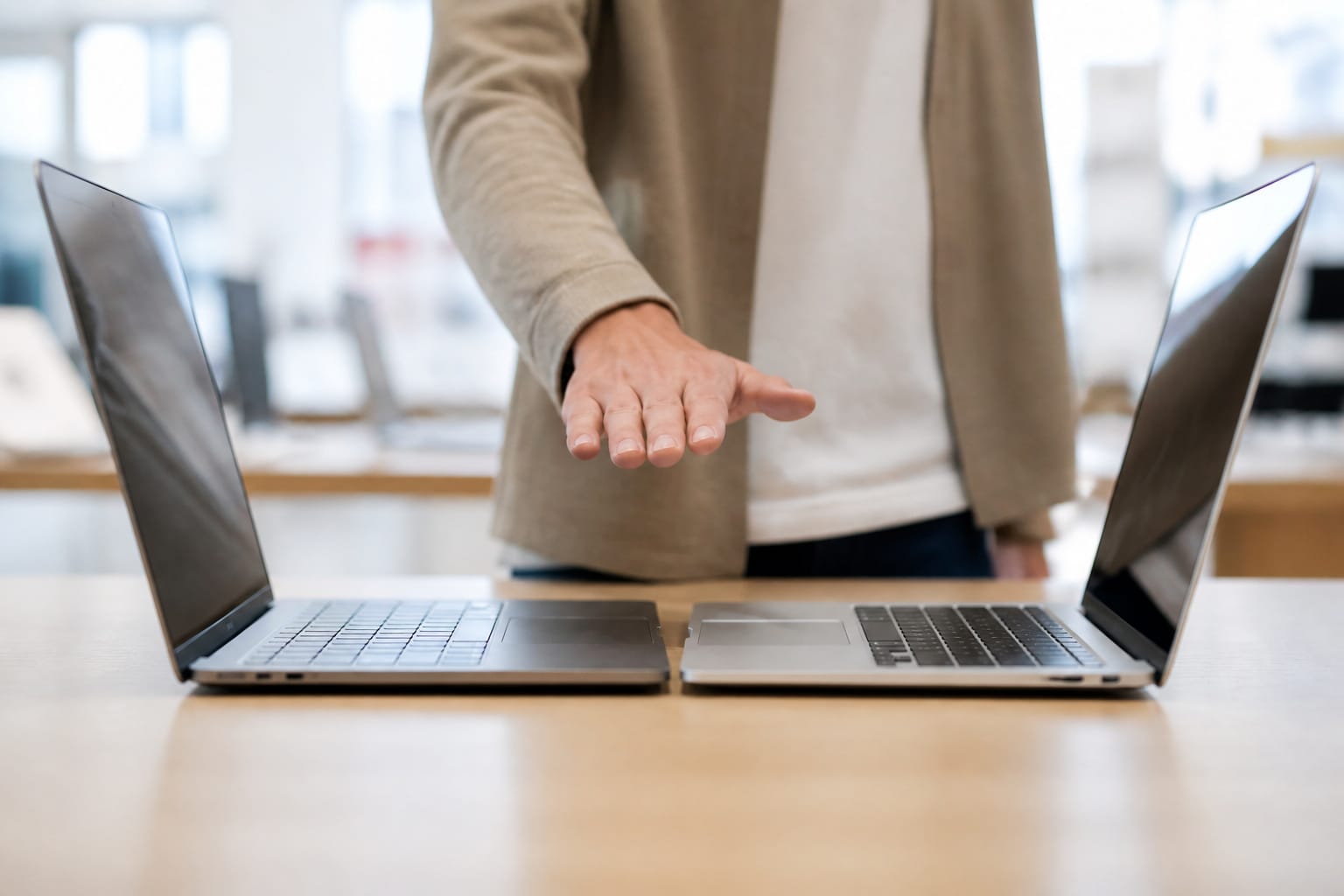 Two laptops side by side as a shopper compares them