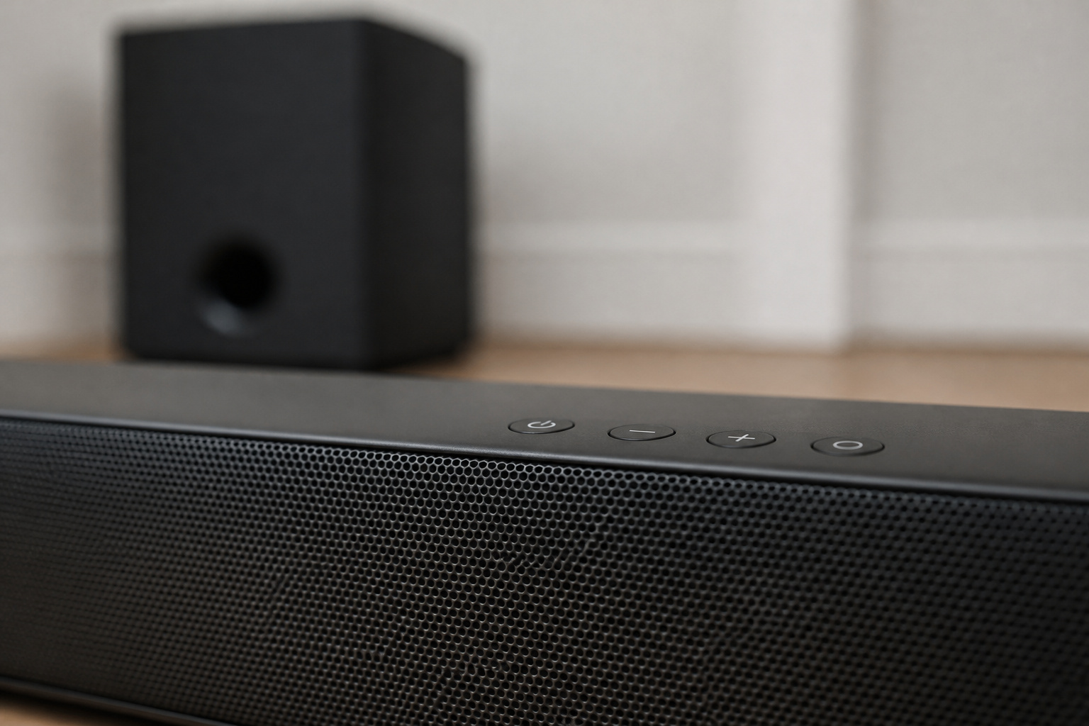 Close-up of a soundbar with a subwoofer behind it