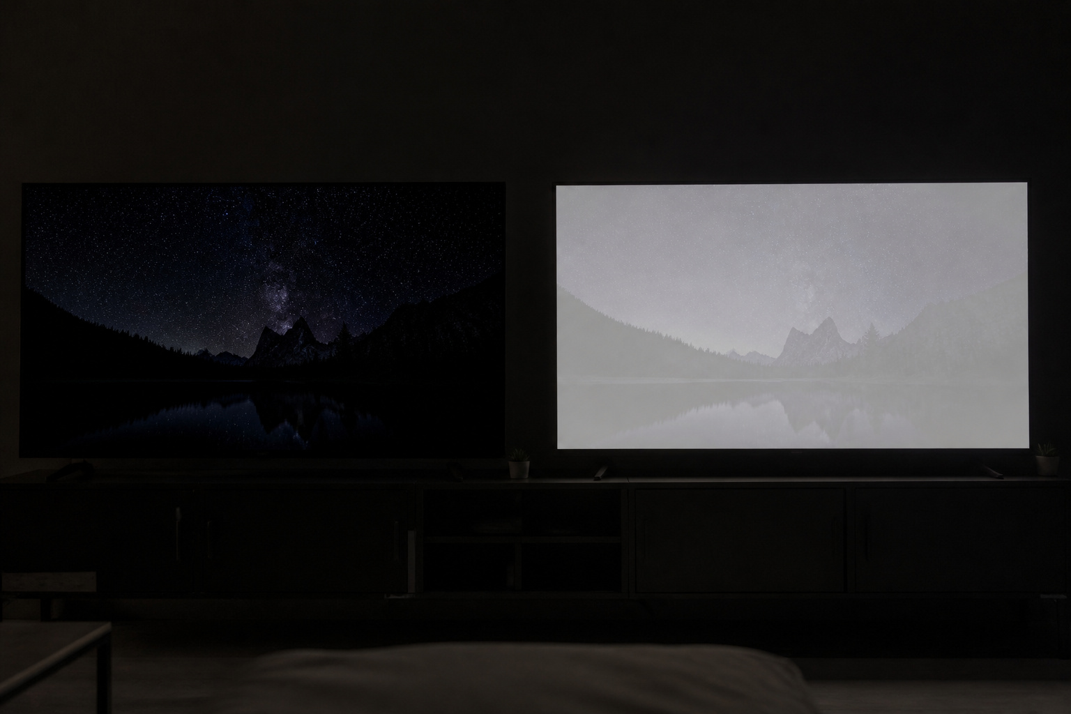 Two TVs showing different black levels in a dim room