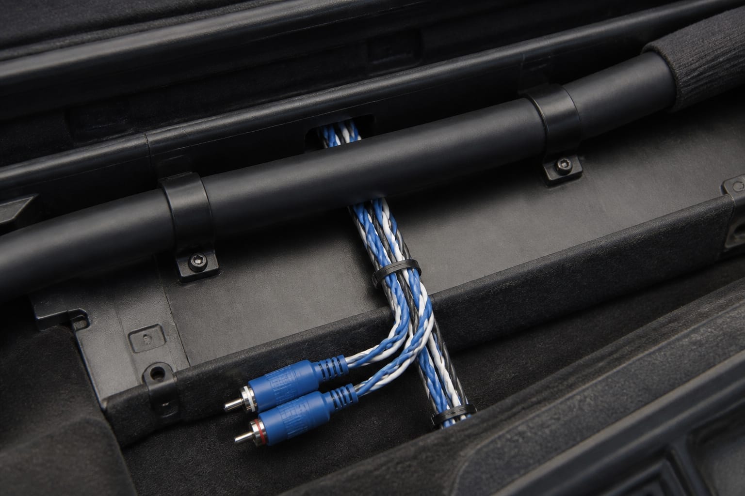 Shielded RCA cables routed away from power wires in a car's wiring channel