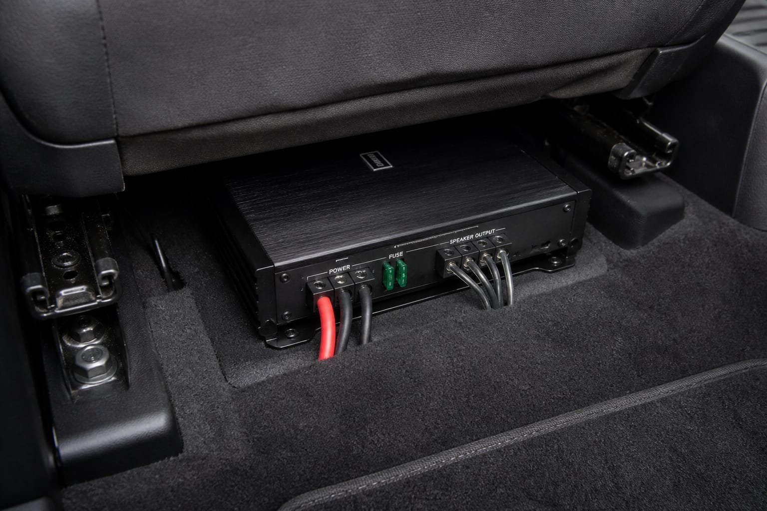 Compact car amplifier mounted under a seat with wiring connected