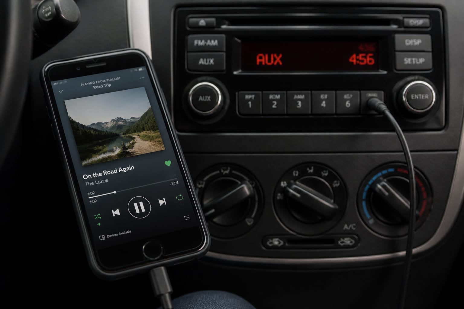 Smartphone connected via direct aux cable to a car stereo for lossless audio