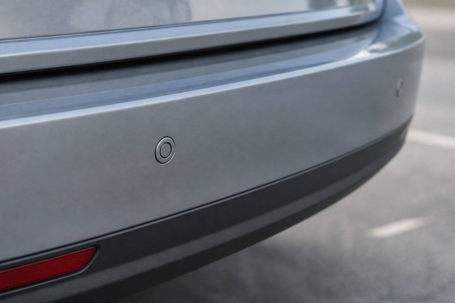 Small round parking sensors embedded in a car's rear bumper