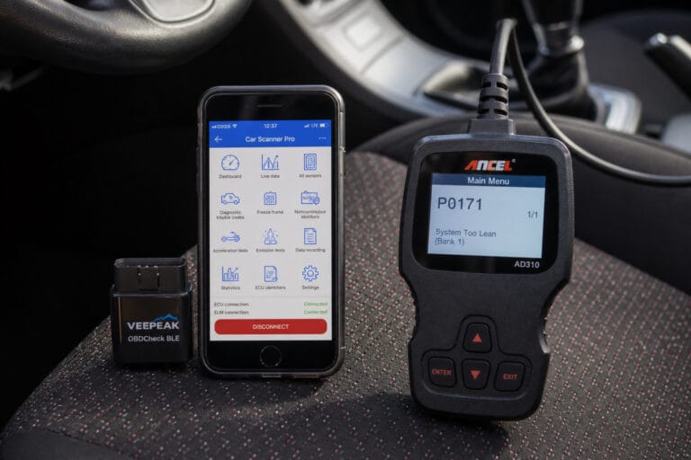 Bluetooth OBD2 dongle with a phone app next to a handheld OBD2 scanner on a car seat