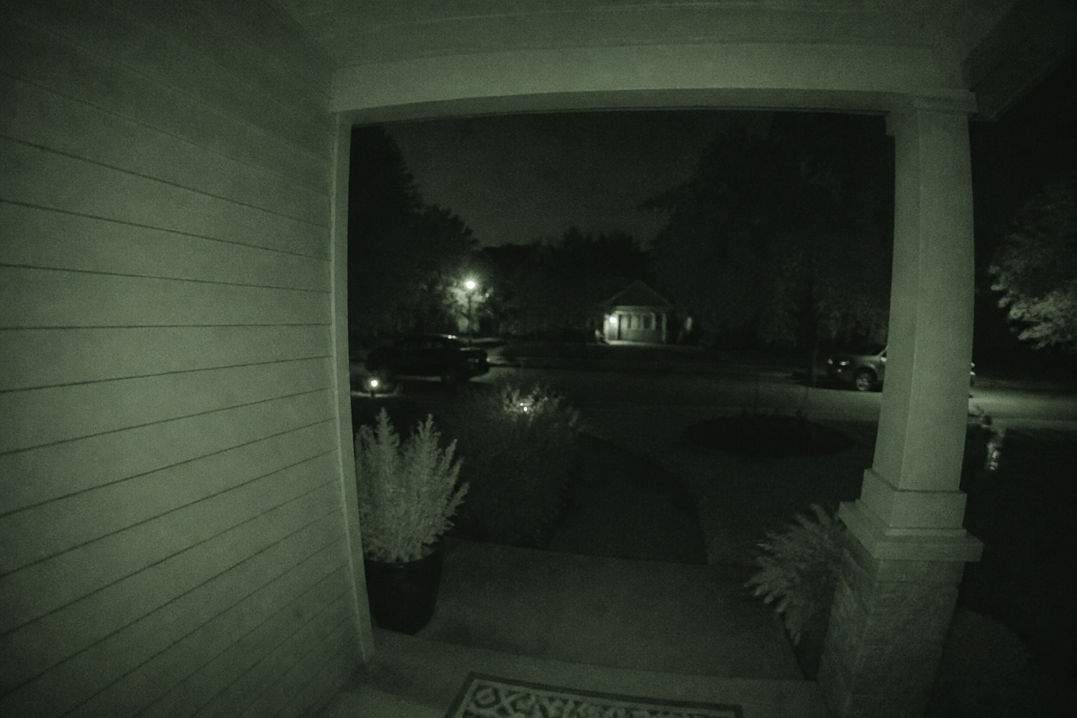 Front porch at night lit by a video doorbell's infrared night vision