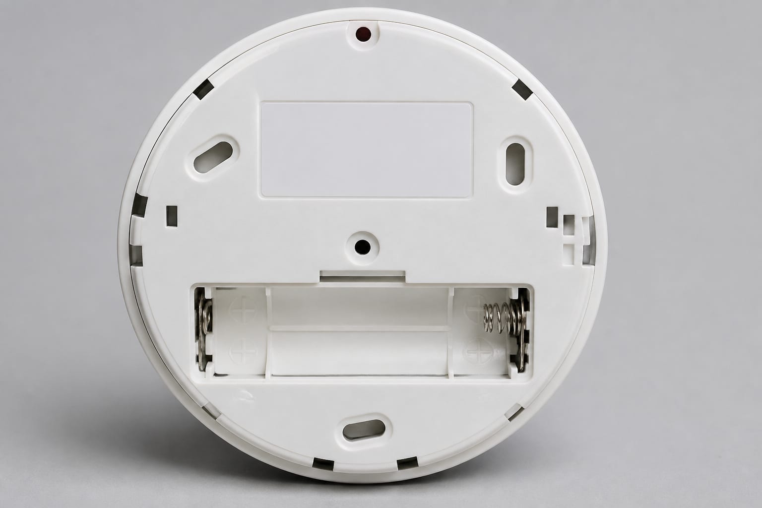 Back of a smoke detector showing the battery compartment and date label area