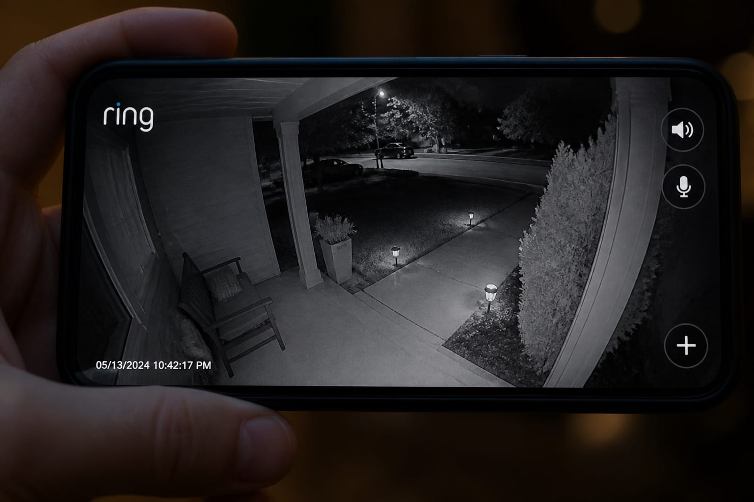 Outdoor security camera's infrared night vision footage shown on a phone screen