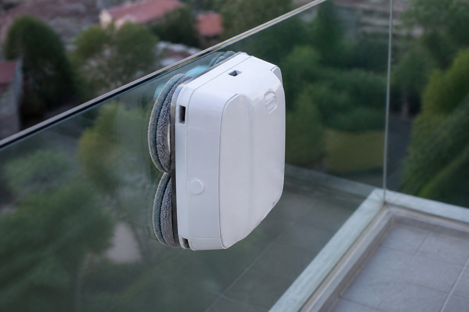 Window cleaning robot at the edge of a frameless glass railing