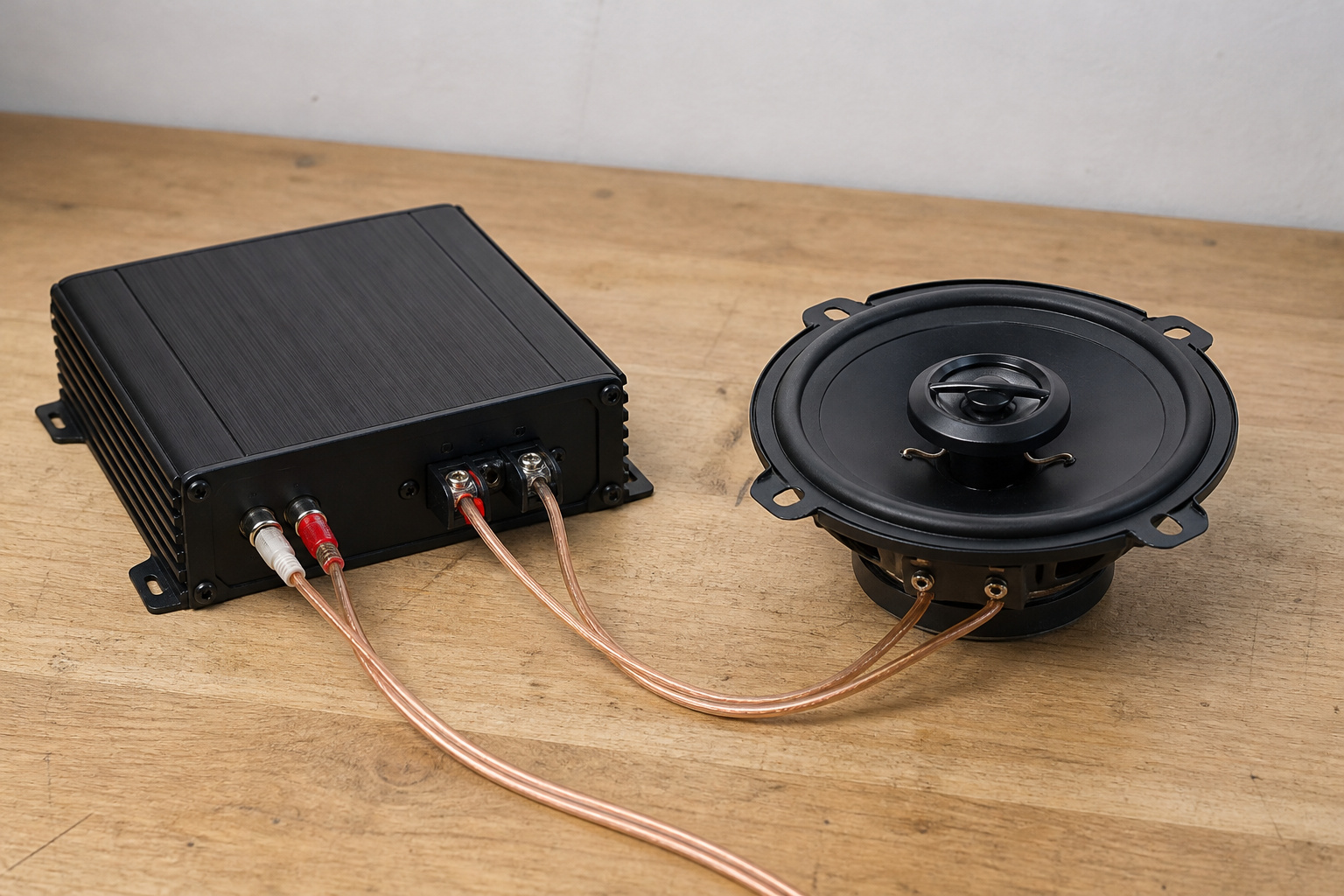 Car amplifier wired to a coaxial speaker on a bench