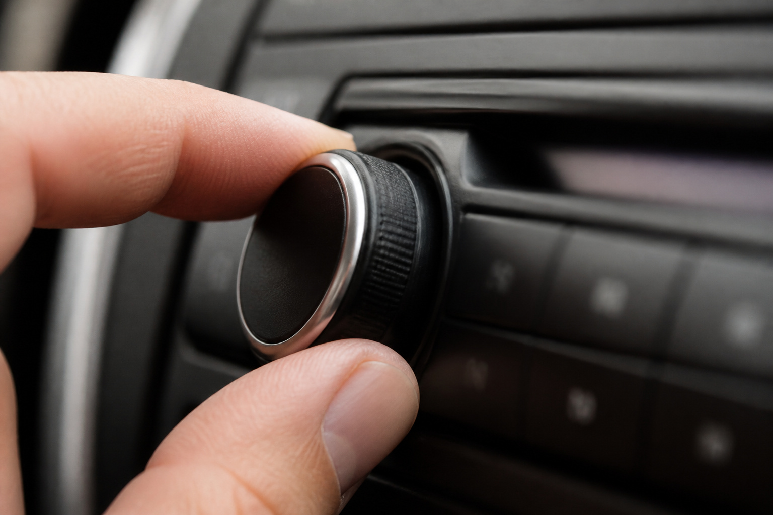 Finger turning a car stereo knob
