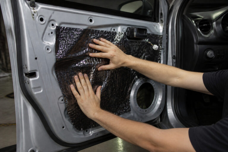 Car door with the panel removed and sound deadening being applied